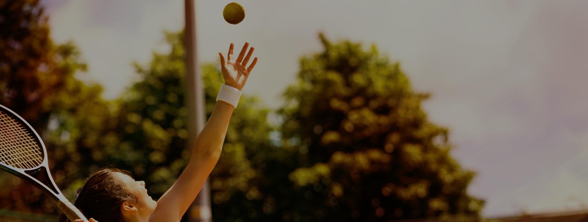 Rear view of tennis player serving during a match
